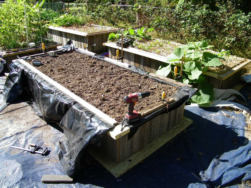 8th wicking bed compost added trim going on.jpg